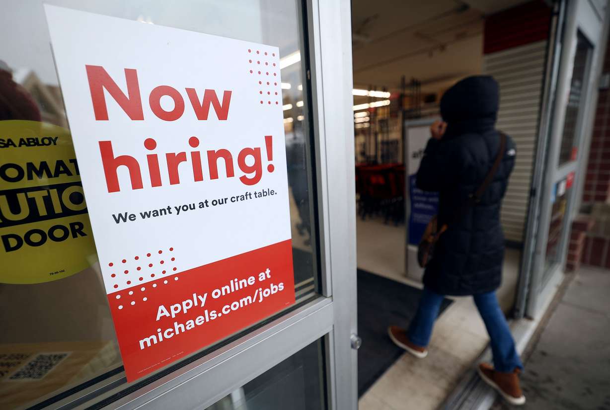 A “Now hiring!” sign is pictured on the door to Michaels in Salt Lake City on Friday.