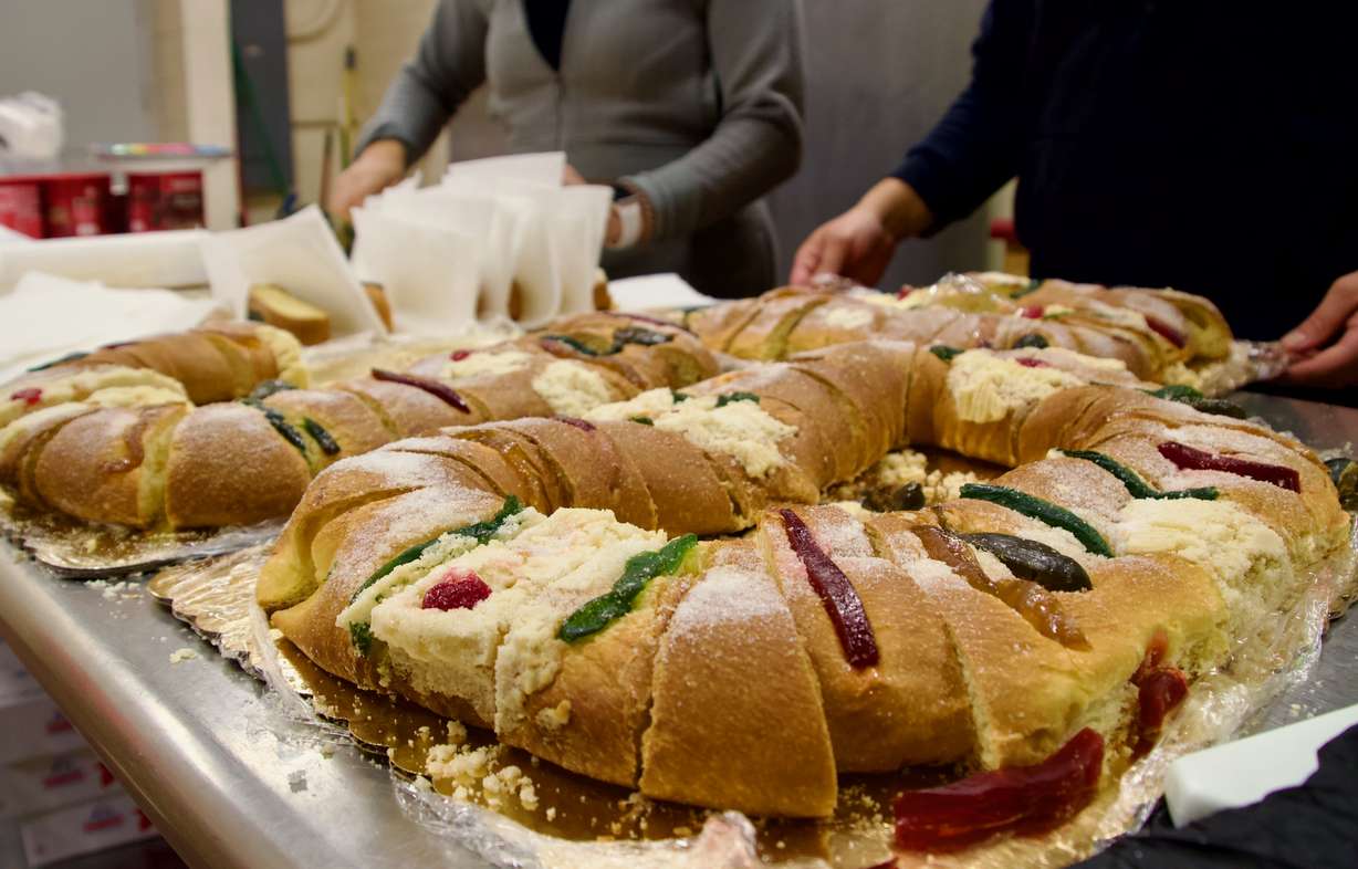 Volunteers cut a rosca de los reyes into pieces at a Día de los Reyes Celebration at Centro Civico Mexicano on Friday.