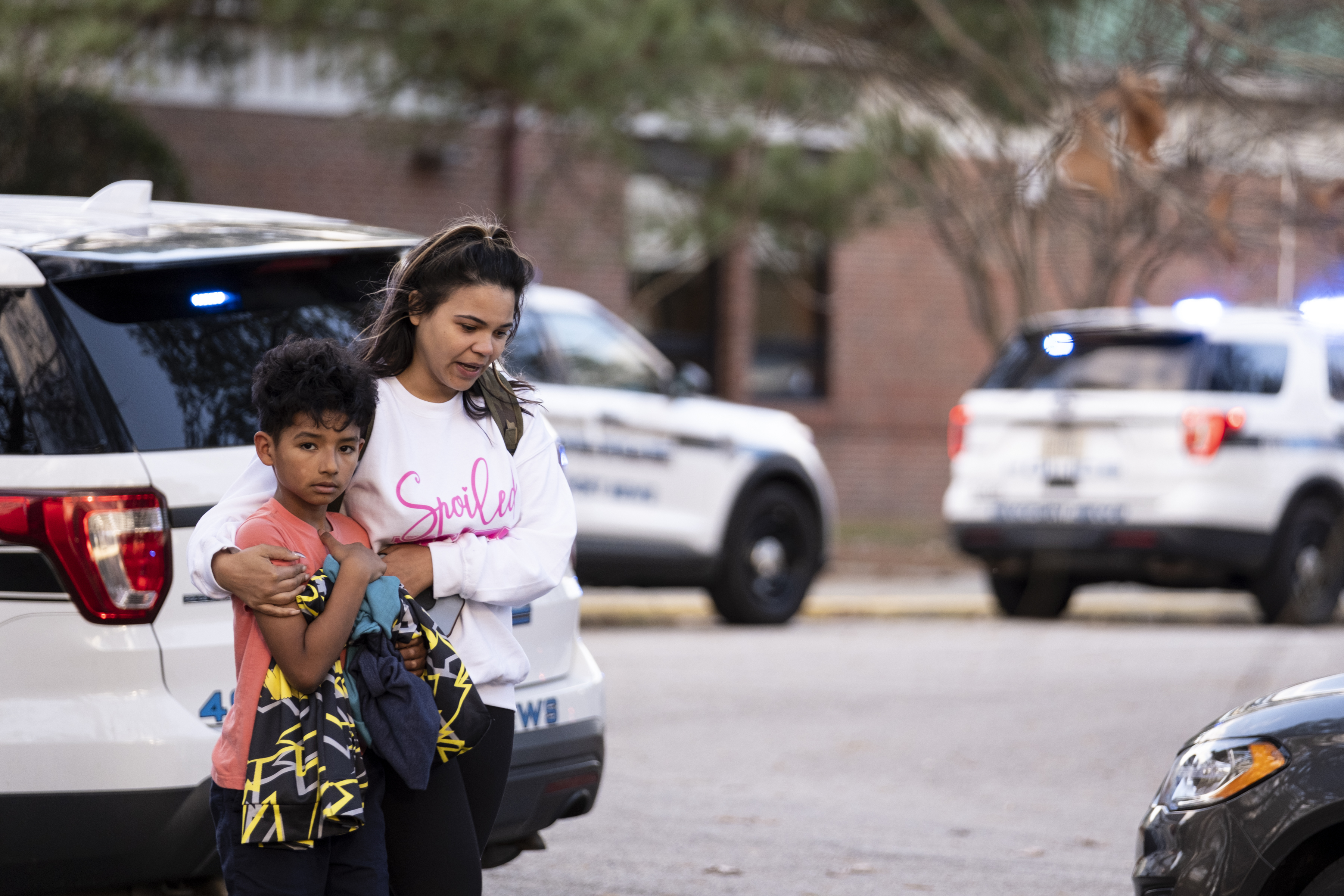 Carlos Glover, age 9, a fourth grader at Richneck Elementary School, is held by his mother Joselin Glover as they leave the school, Friday, in Newport News, Va. A shooting at a Virginia elementary school sent a teacher to the hospital and ended with “an individual” in custody Friday, police and school officials in the city of Newport News said.