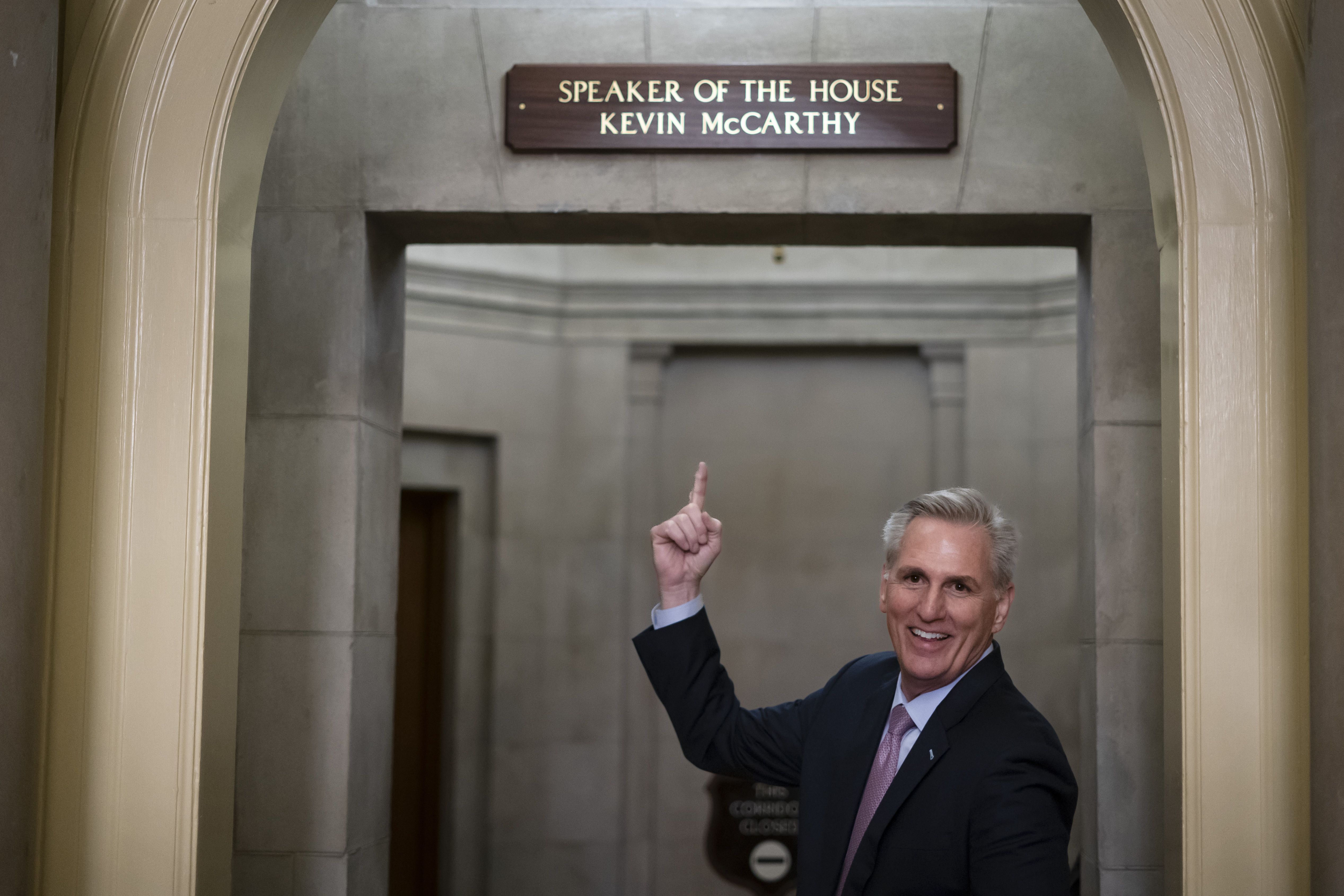 House Speaker Kevin McCarthy of Calif., gestures toward the newly installed nameplate at his office after he was sworn in as speaker of the 118th Congress in Washington, early Saturday.