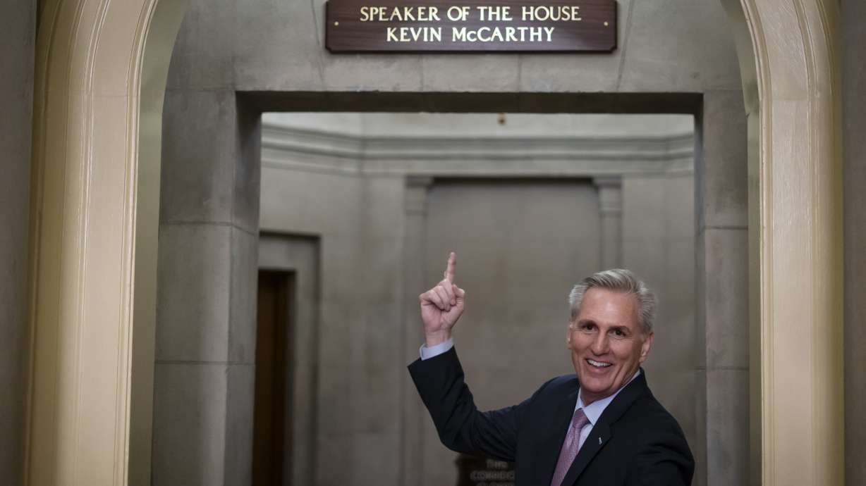 House Speaker Kevin McCarthy of Calif., gestures toward the newly installed nameplate at his office after he was sworn in as speaker of the 118th Congress in Washington, early Saturday.