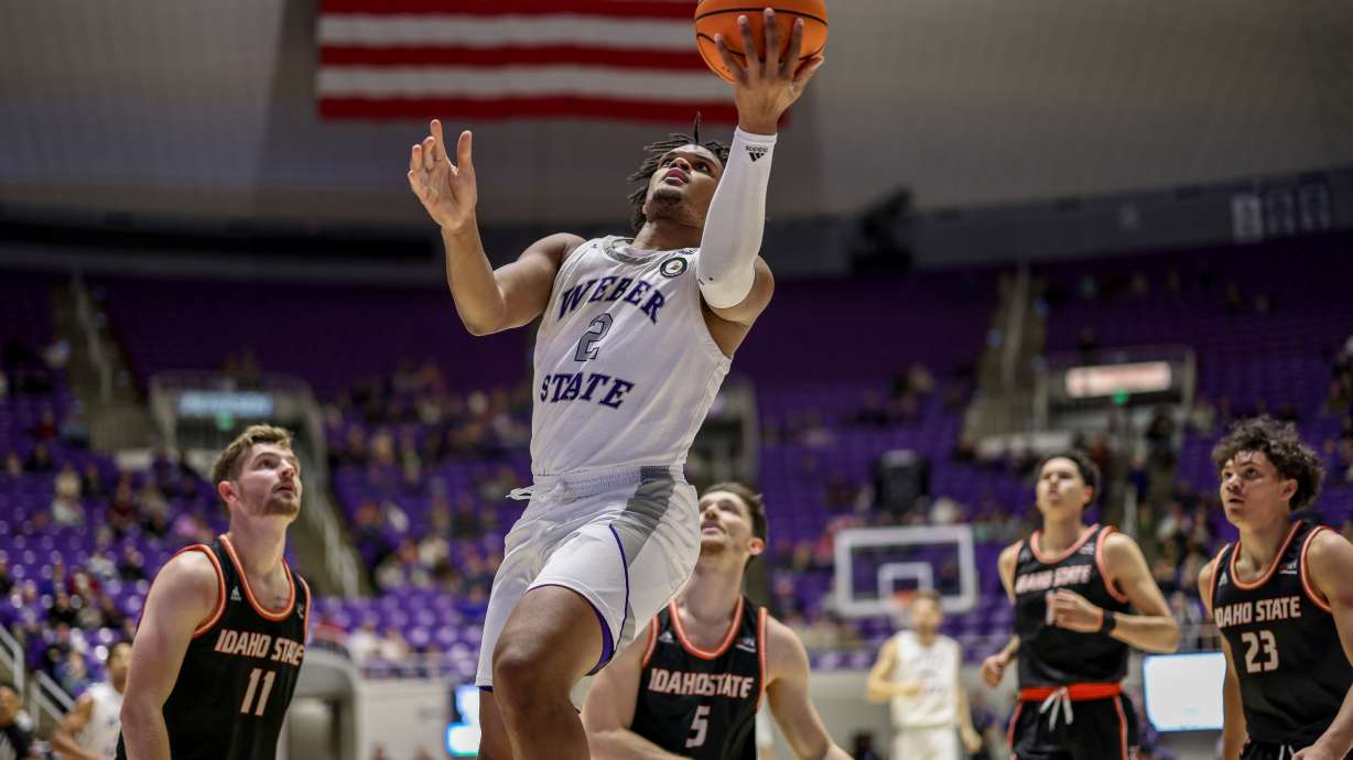 Weber State forward Dillon Jones finishes a layup past Idaho State defenders in a game the Wildcats lost 67-57 on Jan. 7, 2023.