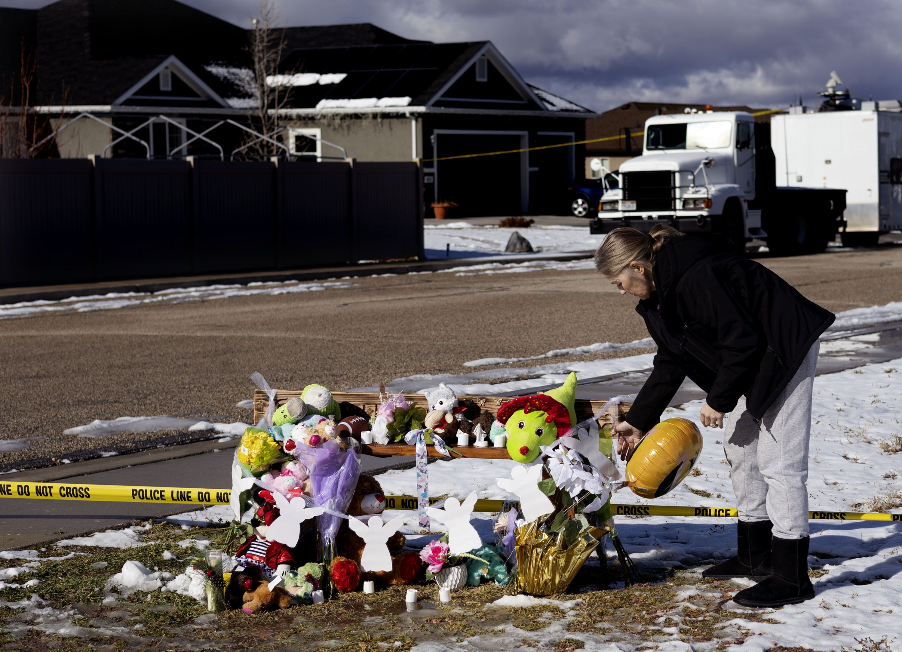 Summer Trammeling of Enoch adds to the memorial across the street from the Haight home in Enoch, Iron County, on Friday. Earlier in the week, police say a man shot seven members of his family before taking his own life. Trammeling’s daughters were friends with two of the Haight daughters.