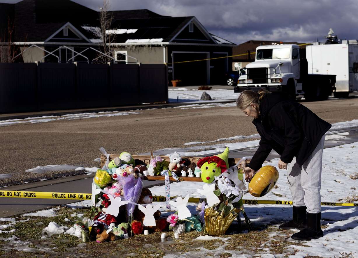 Summer Trammeling of Enoch adds to the memorial across the street from the Haight home in Enoch, Iron County, on Friday. Earlier in the week, police say a man shot seven members of his family before taking his own life. Trammeling’s daughters were friends with two of the Haight daughters.