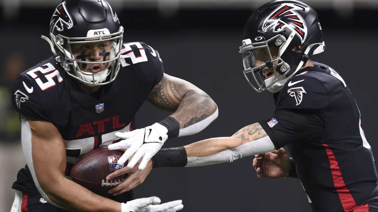 Atlanta Falcons quarterback Desmond Ridder (4) hands off the ball to Atlanta Falcons running back Tyler Allgeier (25) during the first half of an NFL football game against the Tampa Bay Buccaneers, Sunday, Jan. 8, 2023, in Atlanta.