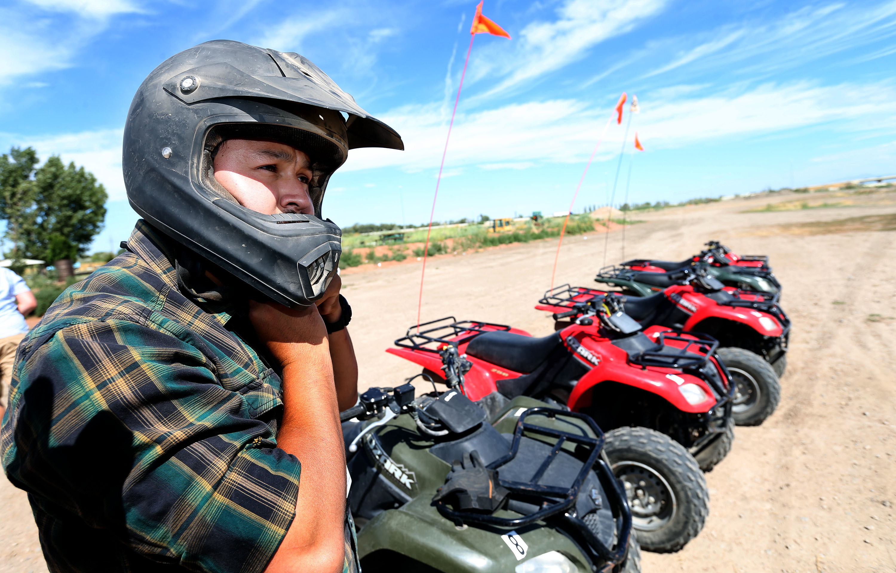 Mike Thomas, an off-highway vehicle program volunteer specialist, straps on a helmet before riding an ATV on July 20, 2017. A new law requires adults to take a free online safety course before they can ride most off-highway vehicles on public lands.