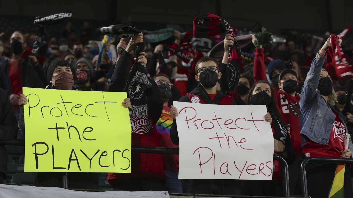 FILE - Portland Thorns fans hold signs during the first half of the team's National Women's Soccer League soccer match against the Houston Dash in Portland, Ore., Oct. 6, 2021. An investigation commissioned by the NWSL and its players union found “widespread misconduct" directed at players dating back to the beginnings nearly a decade ago of the country's top women's professional league.