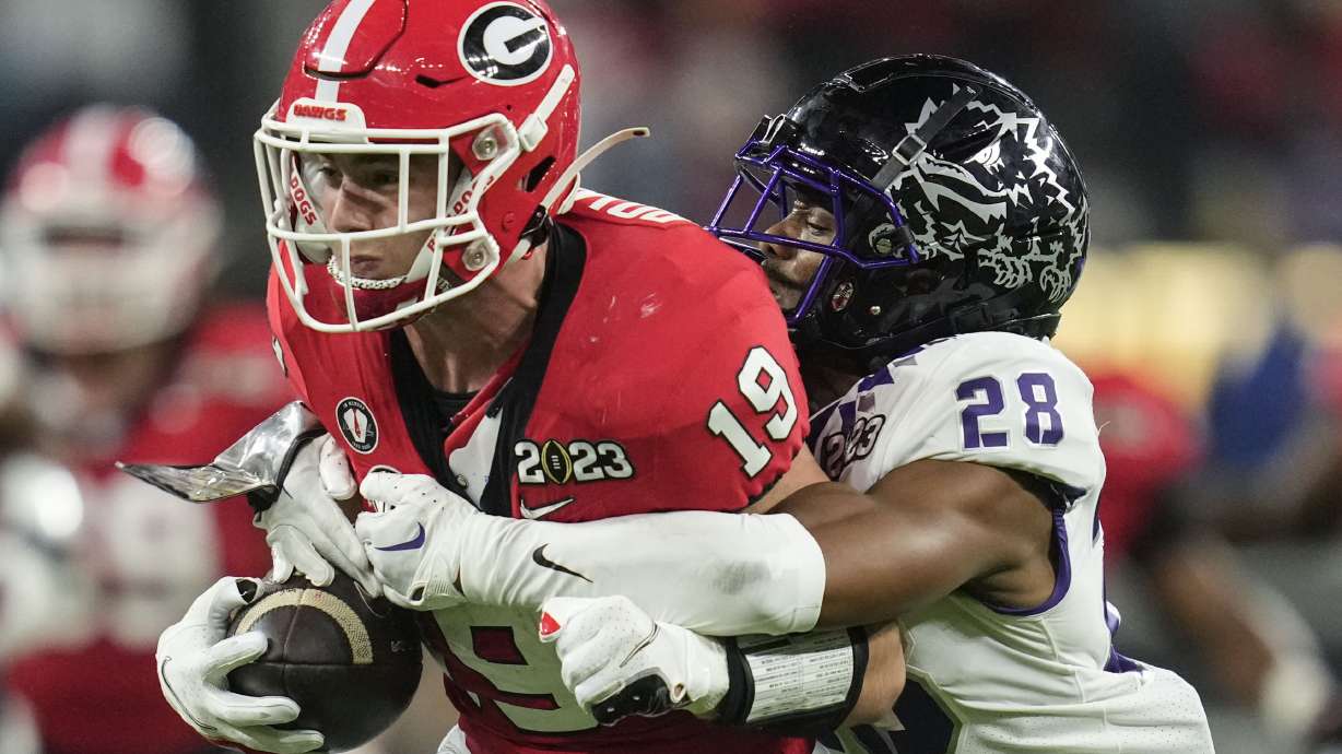 TCU safety Millard Bradford (28) tackles Georgia tight end Brock Bowers (19) during the first half of the national championship NCAA College Football Playoff game, Monday, Jan. 9, 2023, in Inglewood, Calif.