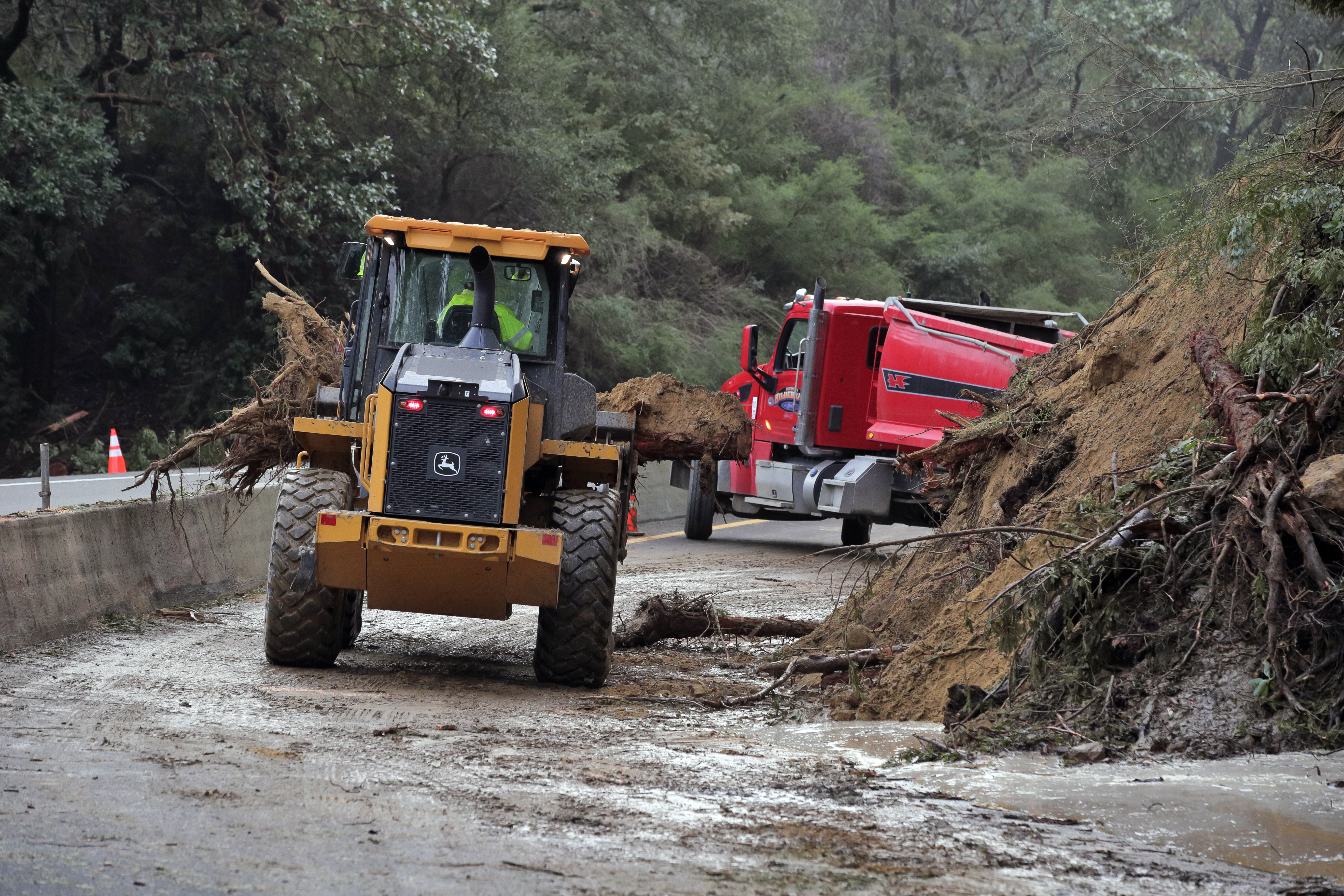 Caltrans crews work to clear a mudslide on Highway 17 that resulted from heavy rain from an atmospheric river storm in the Santa Cruz Mountains in Scott's Valley, Calif., on Monday.