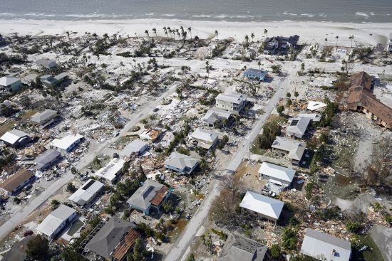 Debris surrounds damaged homes in the aftermath of Hurricane Ian, Sept. 29, 2022, in Fort Myers Beach, Fla. Costly weather disasters kept raining down on America last year, pounding the nation with 18 climate extremes that caused at least $1 billion in damage each, totaling more than $165 billion, federal climate scientists calculated Tuesday.