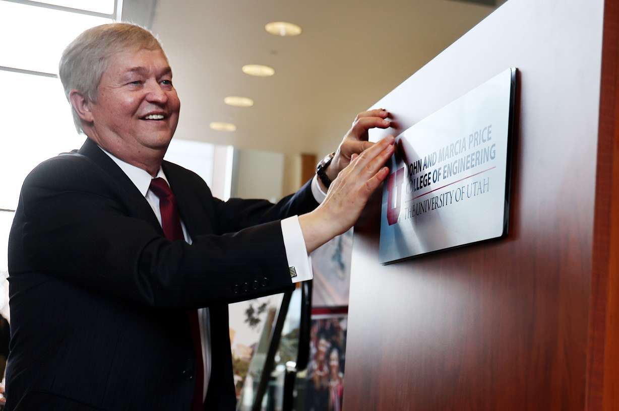 Richard Brown, Dean of the College of Engineering at the University of Utah, sticks a new plaque on the podium as the college is renamed the John and Marcia Price College of Engineering at a ceremony in Salt Lake City on Tuesday.