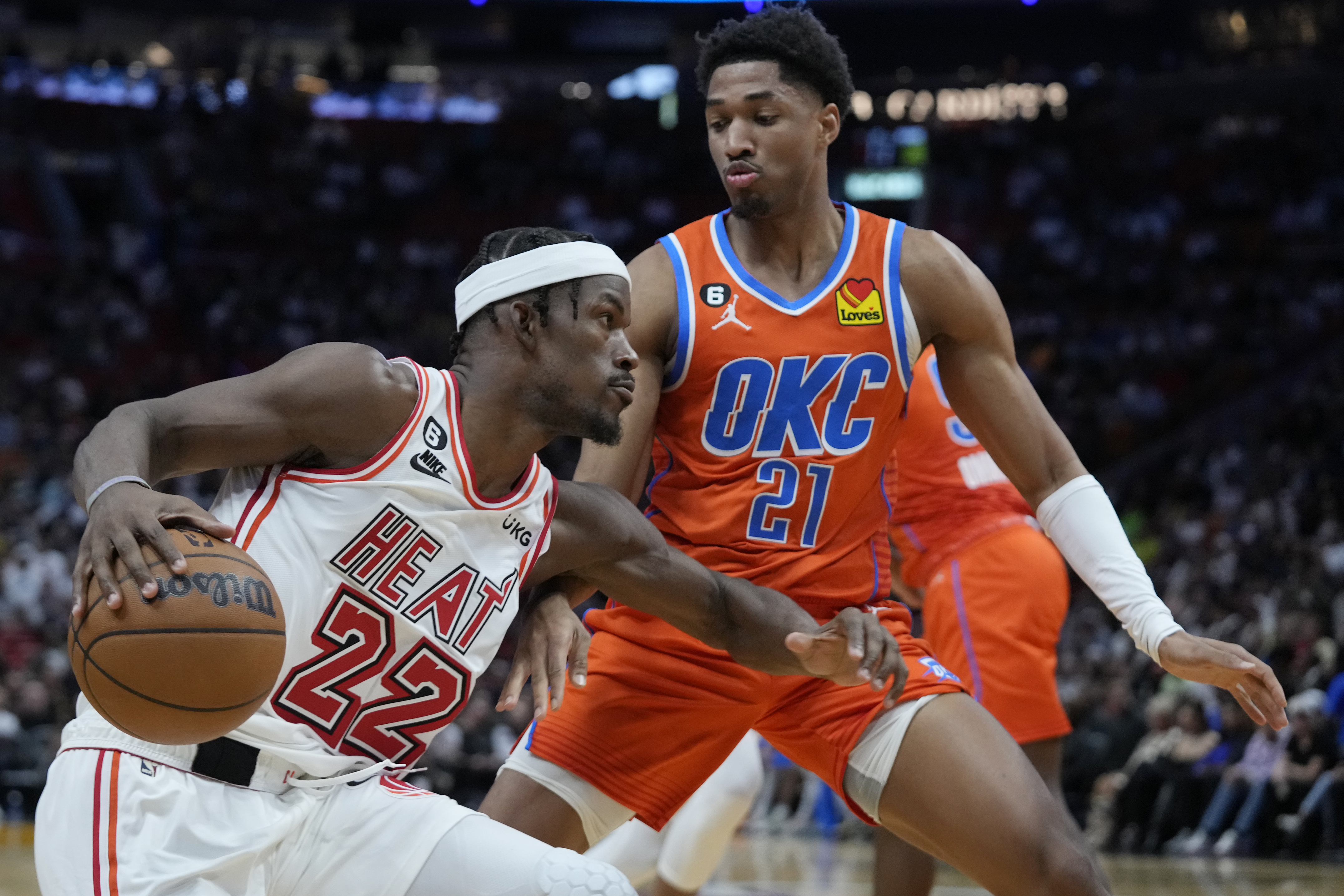 Miami Heat forward Jimmy Butler (22) drives to the basket against Oklahoma City Thunder forward Aaron Wiggins (21) during the first half of an NBA basketball game, Tuesday, Jan. 10, 2023, in Miami. 