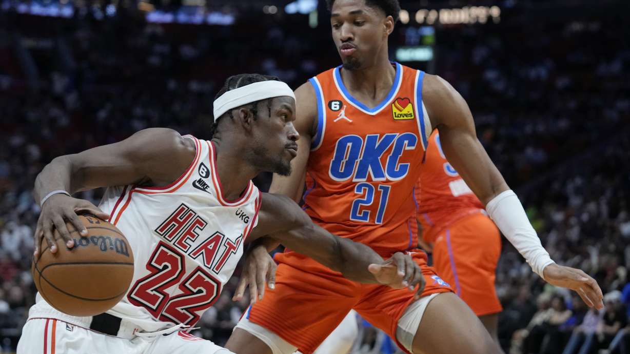 Miami Heat forward Jimmy Butler (22) drives to the basket against Oklahoma City Thunder forward Aaron Wiggins (21) during the first half of an NBA basketball game, Tuesday, Jan. 10, 2023, in Miami.