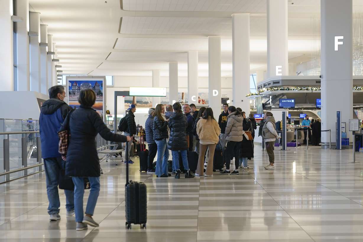 Travelers stand in the departures hall of Terminal B at LaGuardia Airport in New York, Wednesday.