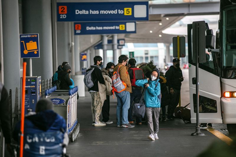 Passengers exit a bus at Terminal 2 as they wait for the resumption of flights at O'Hare International Airport after the Federal Aviation Administration ordered airlines to suspend all domestic departures due to a disruption in the system, in Chicago on Wednesday.
