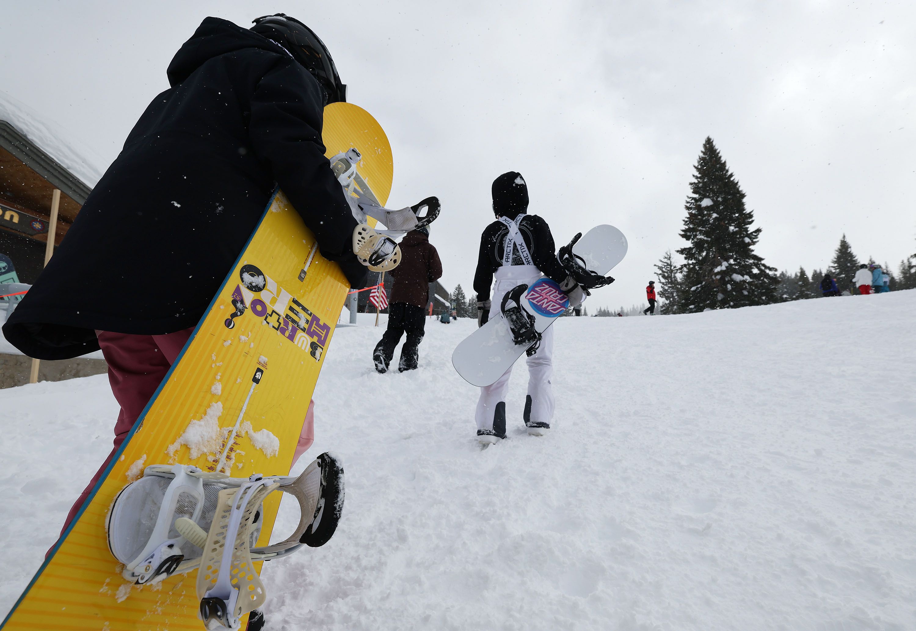 Snowboarders walk to the lift at Brighton Ski Resort on Wednesday. Officials say four Wasatch Front resorts have more snow than anywhere else in the country