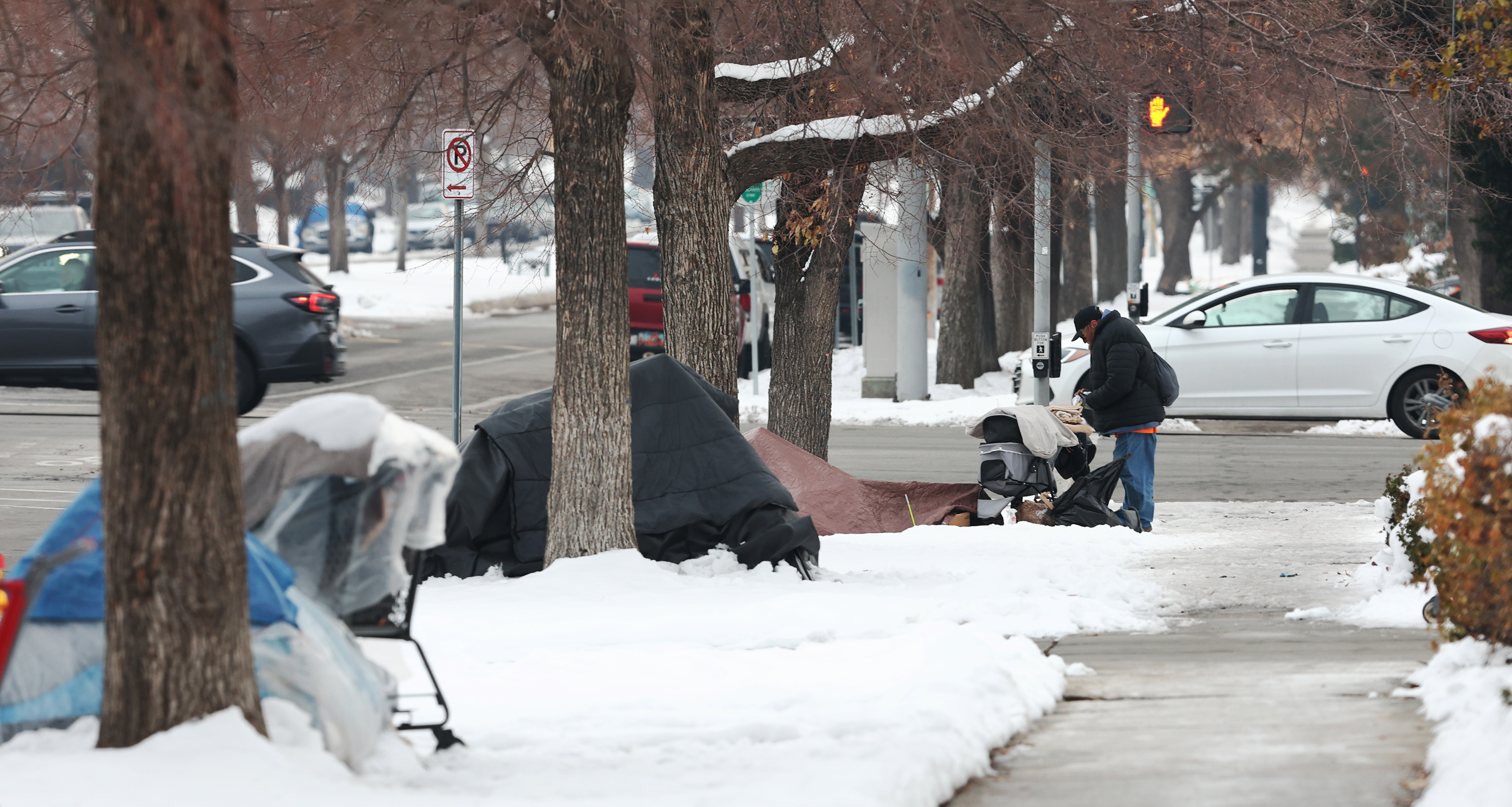 A man stands at one of three homeless tent camps in Salt Lake City on Dec. 20, 2022. At least three unsheltered people have died on Provo's streets this winter, homeless advocates and police have confirmed. 