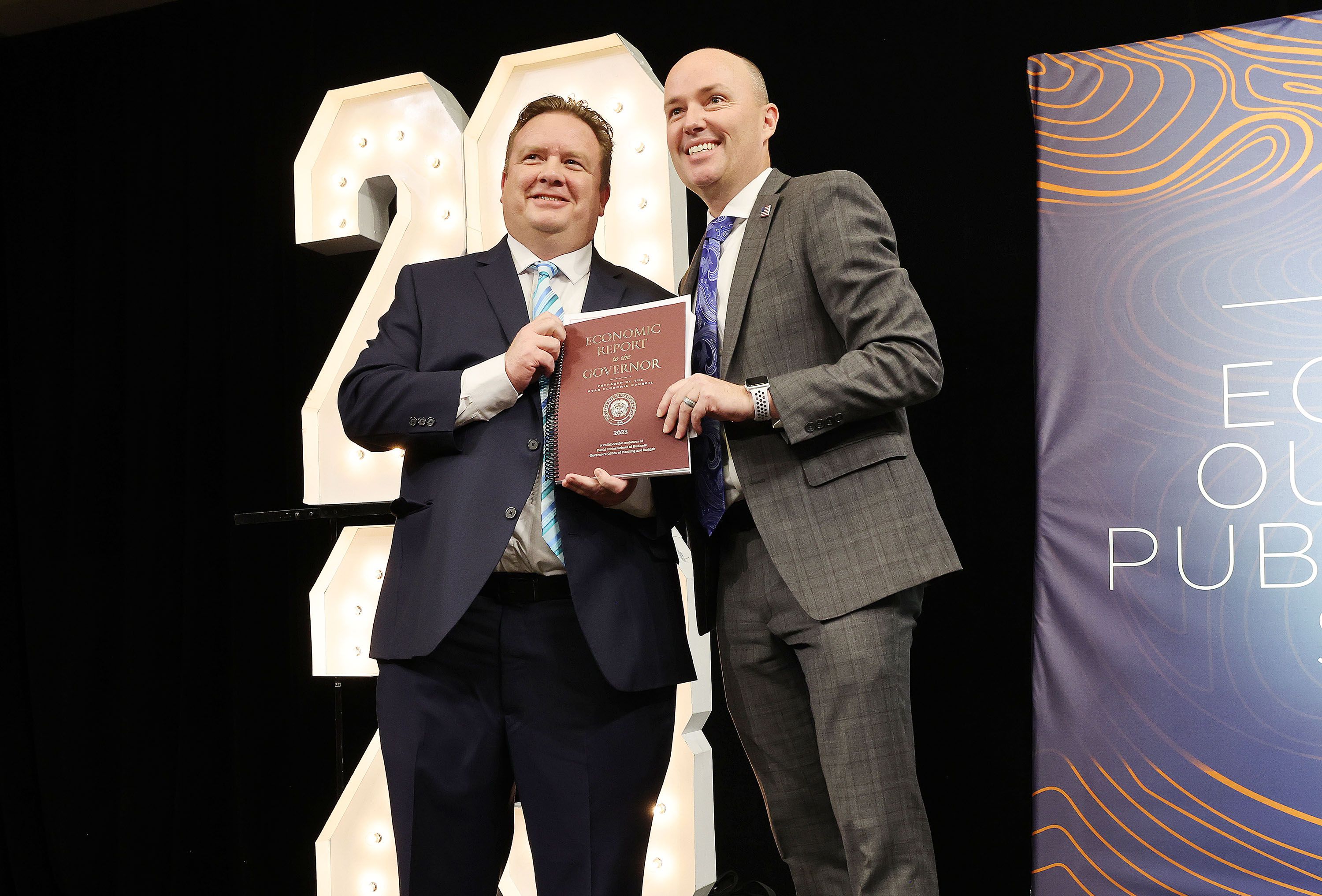 Phil Dean, chief economist and public finance senior research fellow at the Kem C. Gardner Policy Institute, presents the economic report to Gov. Spencer Cox during the Utah Economic Outlook and Public Policy Summit in Salt Lake City on Thursday.