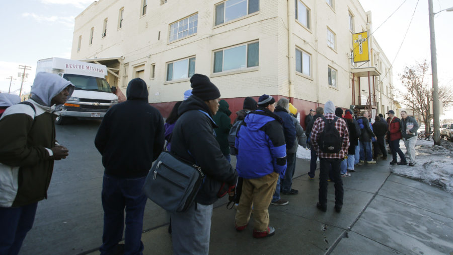 Men stand in line to eat dinner as the Rescue Mission of Salt Lake hosts its annual Christmas dinner for the homeless in Salt Lake City, Dec. 24, 2013.