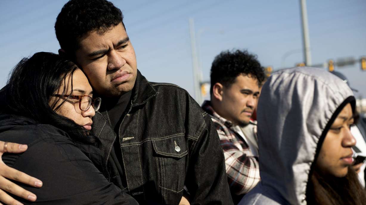 Friends and family members of 15-year-old Paul Tahi and 14-year-old Tivani Lopati console one another at a memorial in West Valley on Jan. 14, 2022. The two teenagers were shot and killed on a sidewalk the day before.
