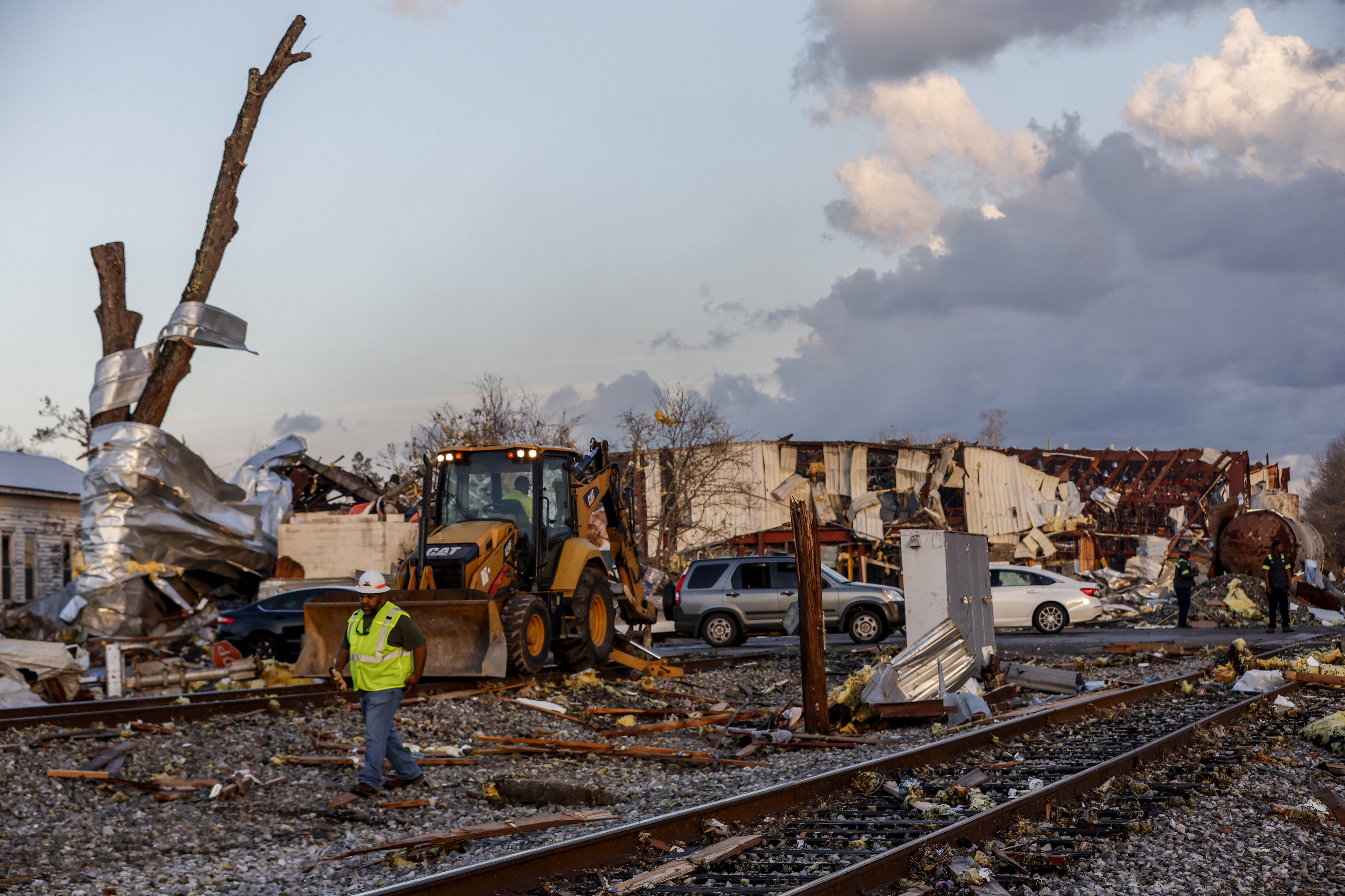Workers remove debris from railroad tracks after a tornado passed through downtown Selma, in Selma Ala.