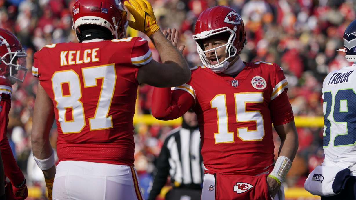 Kansas City Chiefs quarterback Patrick Mahomes (15) and tight end Travis Kelce (87) celebrate during the first half of an NFL football game against the Seattle Seahawks Saturday, Dec. 24, 2022, in Kansas City, Mo.