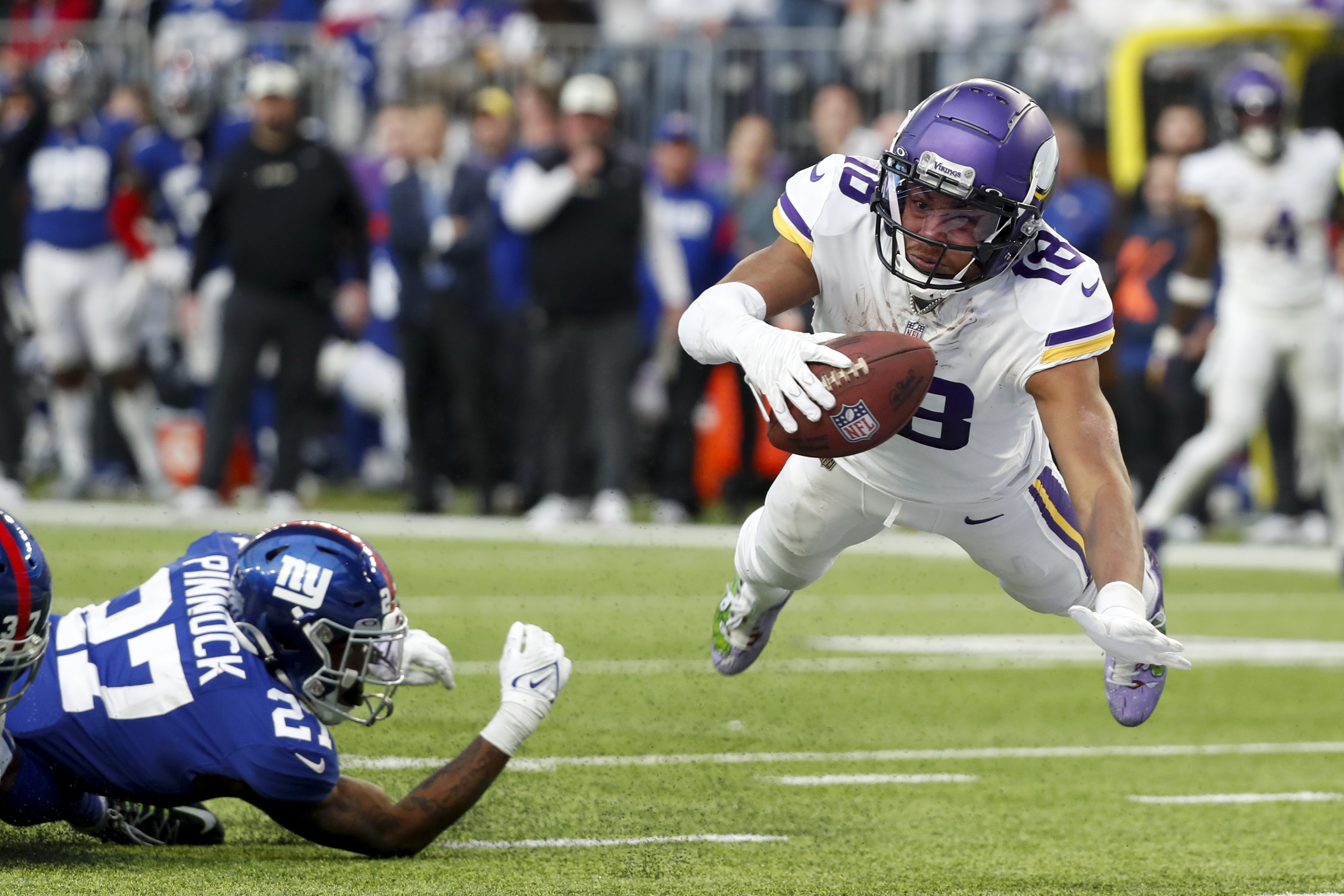 Minnesota Vikings wide receiver Justin Jefferson (18) catches a 17-yard touchdown pass ahead New York Giants cornerback Jason Pinnock (27) during the second half of an NFL football game, Saturday, Dec. 24, 2022, in Minneapolis.