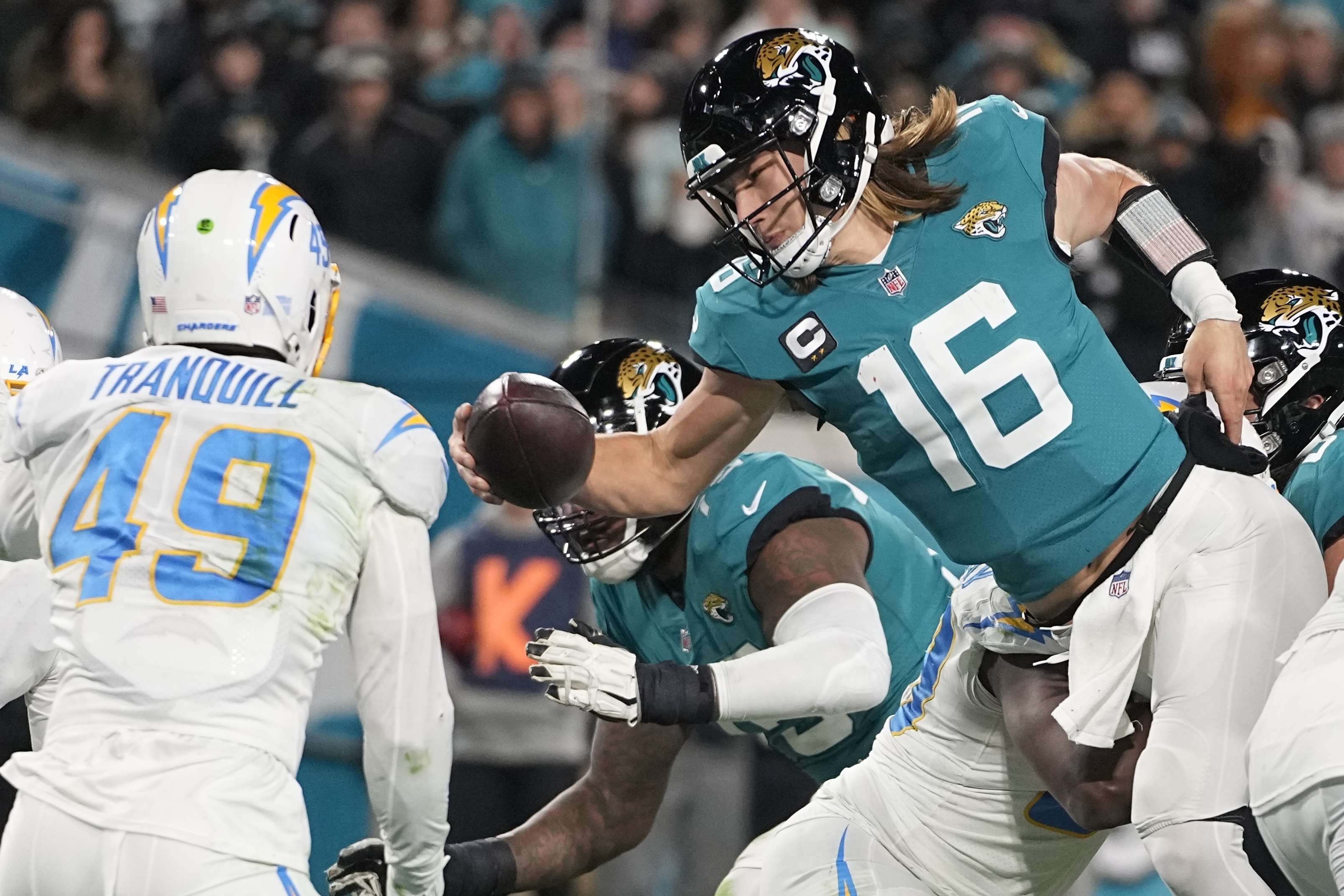 Jacksonville Jaguars quarterback Trevor Lawrence (16) leaps for a two-point conversion against the Los Angeles Chargers during the second half of an NFL wild-card football game, Saturday, Jan. 14, 2023, in Jacksonville, Fla.