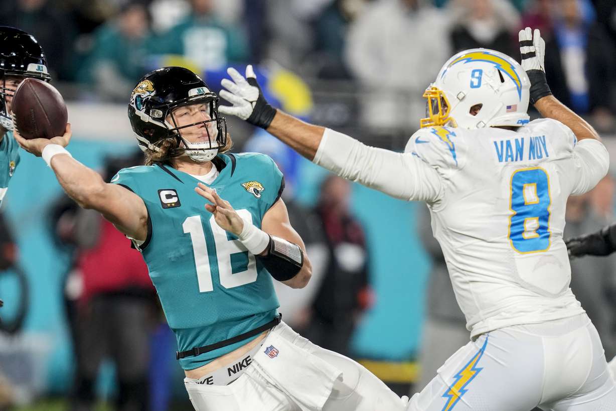 Jacksonville Jaguars quarterback Trevor Lawrence (16) tries to throw a pass under pressure by Los Angeles Chargers linebacker Kyle Van Noy (8) during the second half of an NFL wild-card football game, Saturday, Jan. 14, 2023, in Jacksonville, Fla.