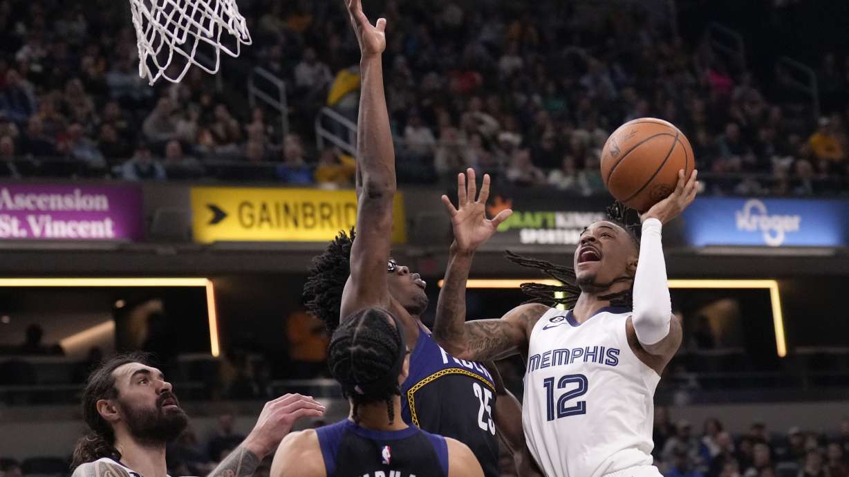 Memphis Grizzlies guard Ja Morant (12) shoots around Indiana Pacers forward Jalen Smith (25) during the first half of an NBA basketball game in Indianapolis, Saturday, Jan. 14, 2023.