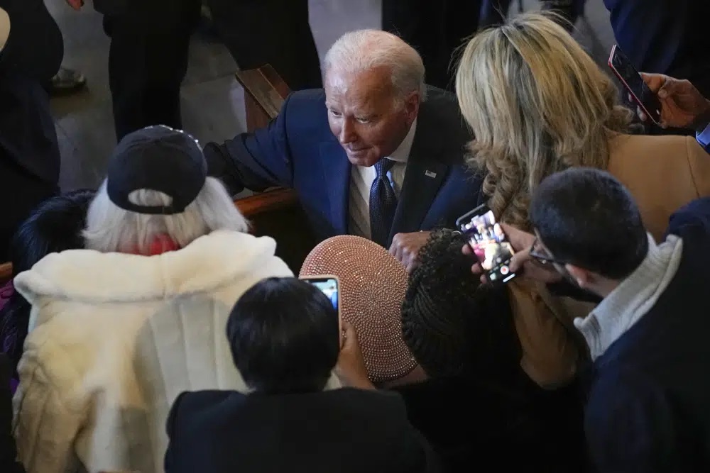President Joe Biden greats Christine King Farris, Martin Luther King Jr.'s sister, in the pink hat seated at Ebenezer Baptist Church in Atlanta, Sunday during a service honoring Martin Luther King Jr.