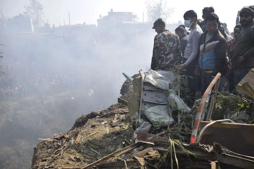 Nepalese rescue workers and civilians gather around the wreckage of a passenger plane that crashed in Pokhara, Nepal, Sunday. Authorities in Nepal said 68 people have been confirmed dead after a regional passenger plane with 72 aboard crashed.