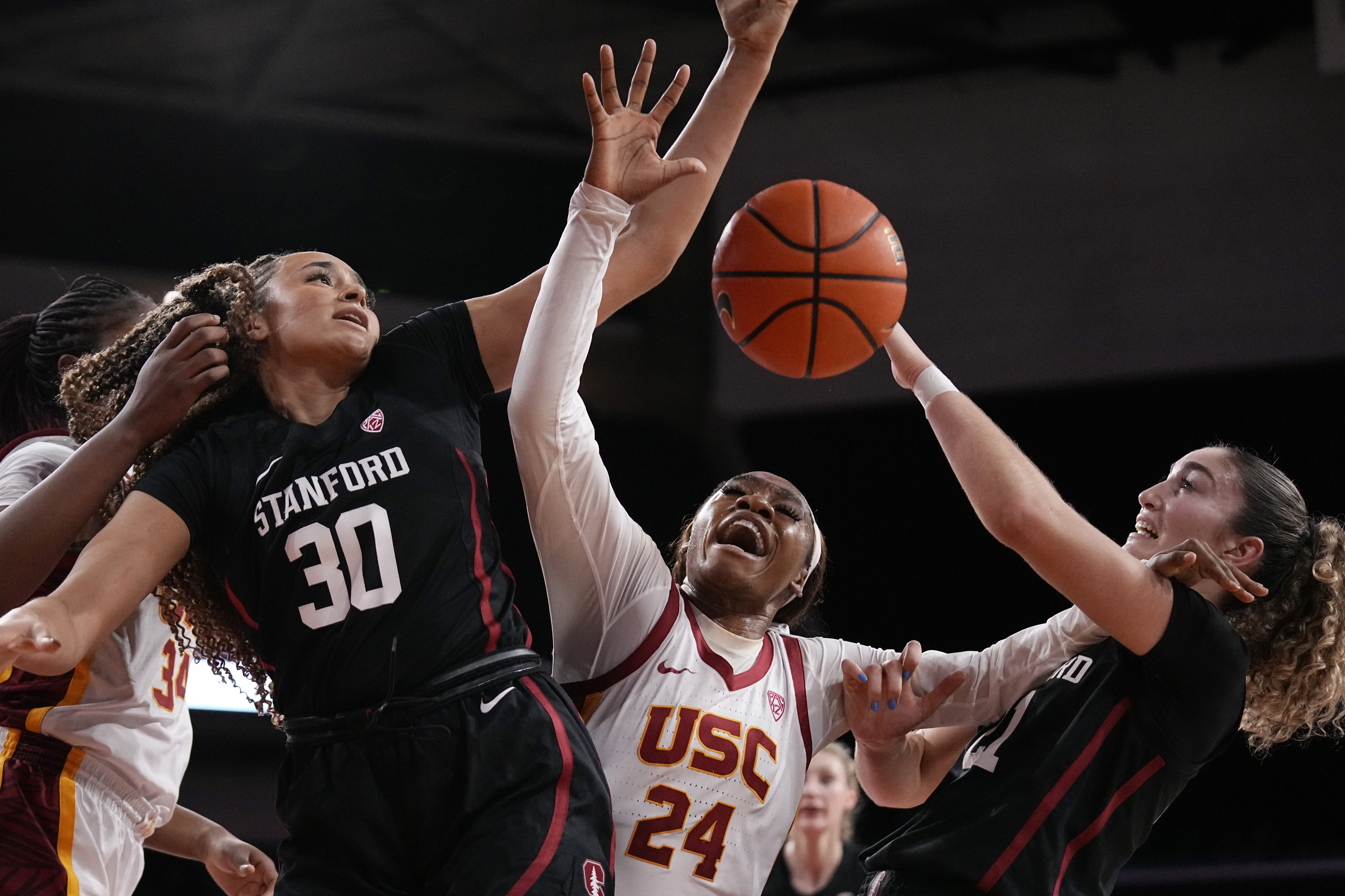 Stanford guard Haley Jones (30) and forward Brooke Demetre (21) grapple for a loose ball with Southern California guard Okako Adika (24) during the first half of an NCAA college basketball game Sunday, Jan. 15, 2023, in Los Angeles. 