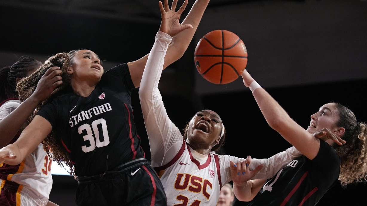 Stanford guard Haley Jones (30) and forward Brooke Demetre (21) grapple for a loose ball with Southern California guard Okako Adika (24) during the first half of an NCAA college basketball game Sunday, Jan. 15, 2023, in Los Angeles.