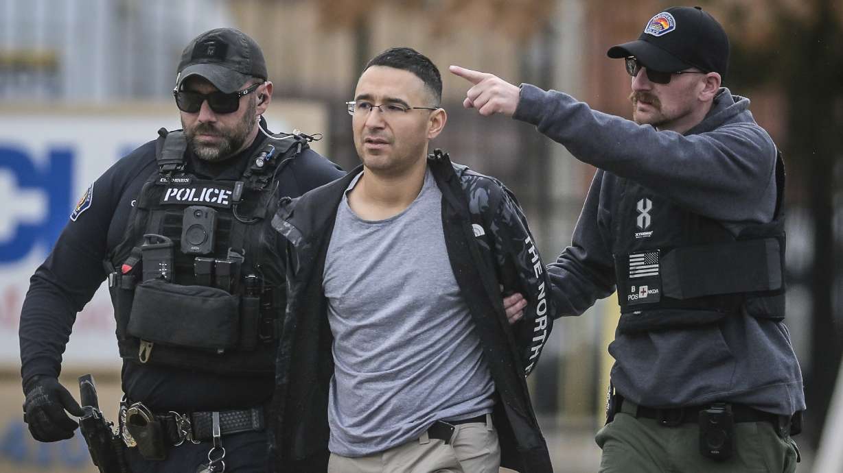 Solomon Pena, center, a Republican candidate for New Mexico House District 14, is taken into custody Monday in southwest Albuquerque, N.M. in connection with a recent series of drive-by shootings targeting Democratic lawmakers.