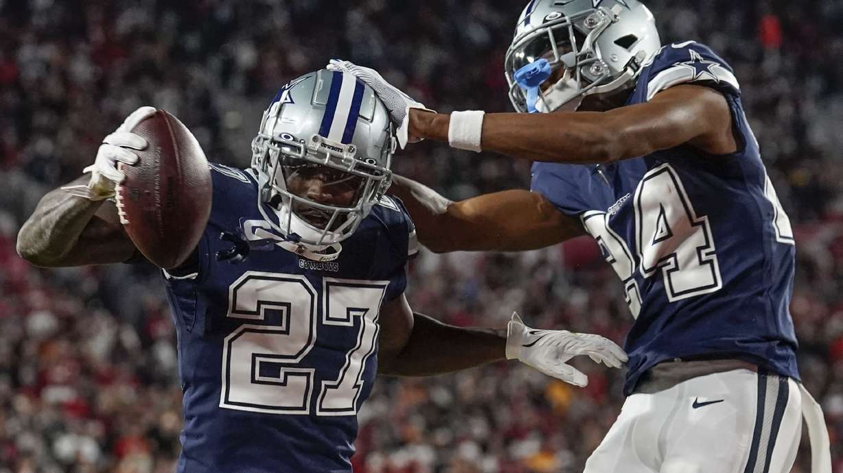 Dallas Cowboys safety Jayron Kearse (27) celebrates with safety Israel Mukuamu after intercepting the ball against Tampa Bay Buccaneers quarterback Tom Brady during the first half of an NFL wild-card football game, Monday, Jan. 16, 2023, in Tampa, Fla.