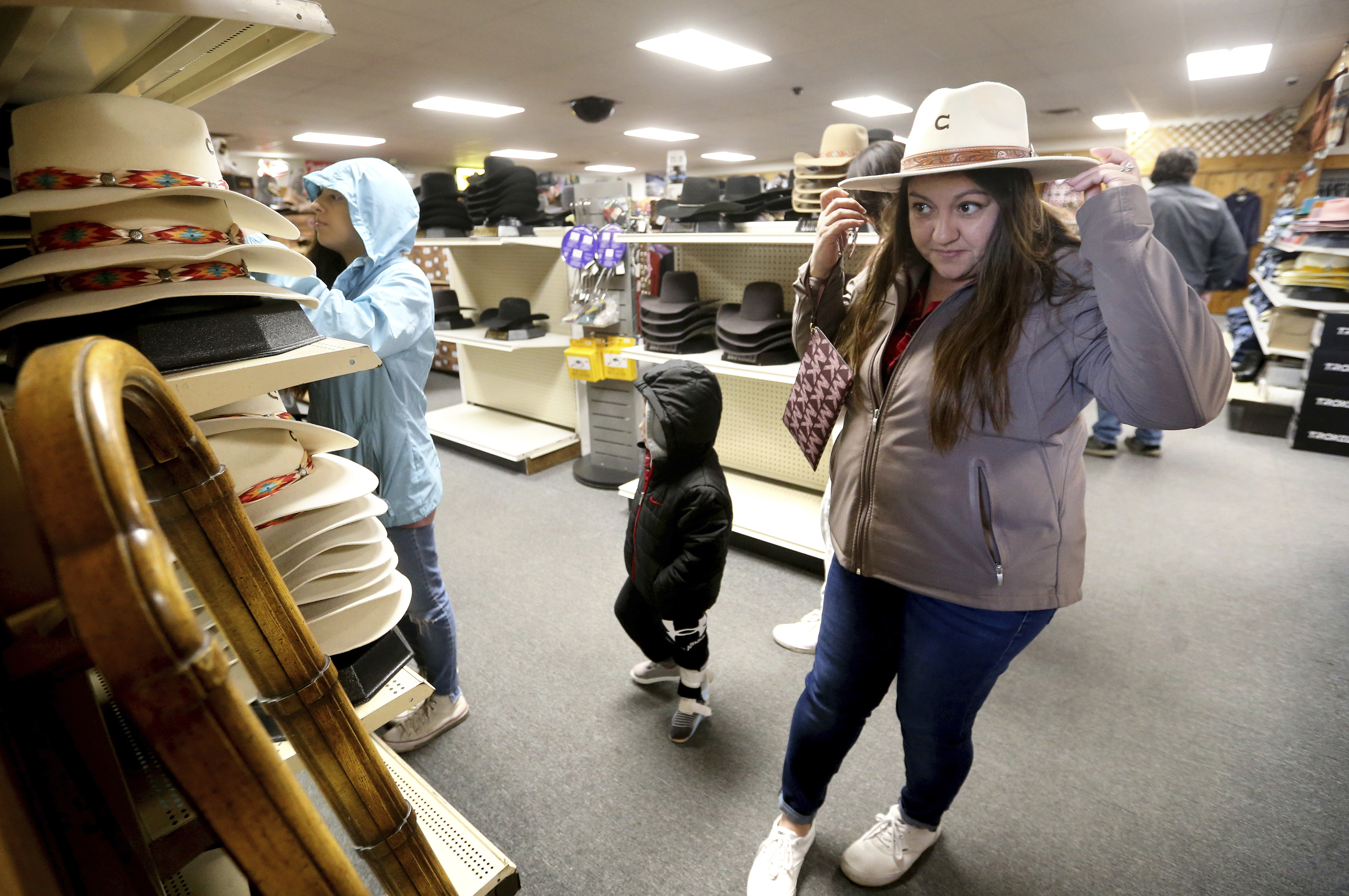 Irene Schaefer, of Johnson Creek, Wis., shops for hats at Longhorn Saddlery in Dubuque, Iowa, on Dec. 30, 2022. Americans cut back on spending in December, the Commerce Department said Wednesday.