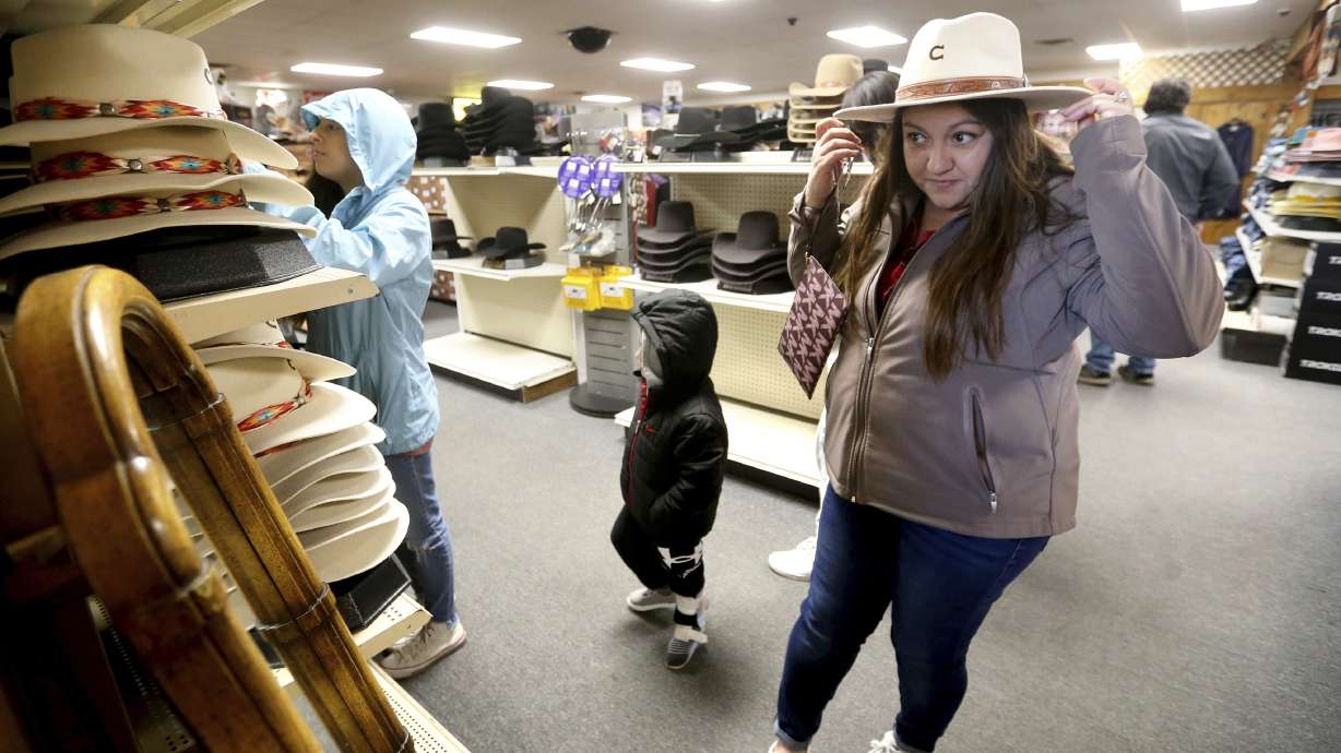 Irene Schaefer, of Johnson Creek, Wis., shops for hats at Longhorn Saddlery in Dubuque, Iowa, on Dec. 30, 2022. Americans cut back on spending in December, the Commerce Department said Wednesday.