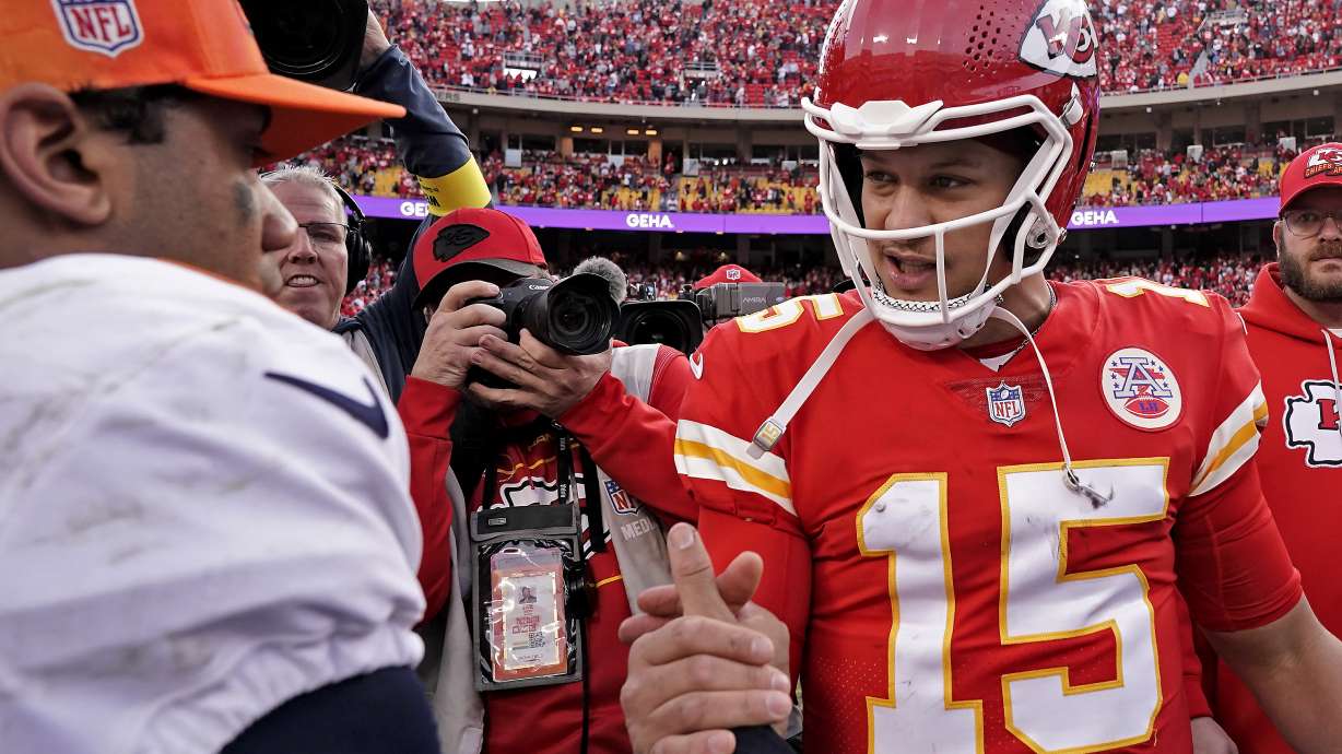 Kansas City Chiefs quarterback Patrick Mahomes (15) and Denver Broncos quarterback Russell Wilson (3) greet each other after an NFL football game Sunday, Jan. 1, 2023, in Kansas City, Mo.