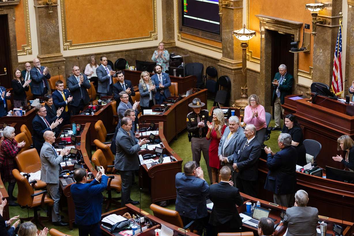 Dr. Stanley Green and retired Utah Highway Patrol trooper Ralph Evans are given a standing ovation in the House of Representatives at the state Capitol in Salt Lake City on Wednesday.