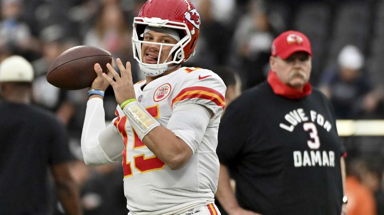 Kansas City Chiefs head coach Andy Reid, right, wears a shirt paying tribute to Buffalo Bills safety Damar Hamlin as he watches Chiefs quarterback Patrick Mahomes warm up before the start of an NFL football game between the Las Vegas Raiders and Kansas City Chiefs Saturday, Jan. 7, 2023, in Las Vegas.