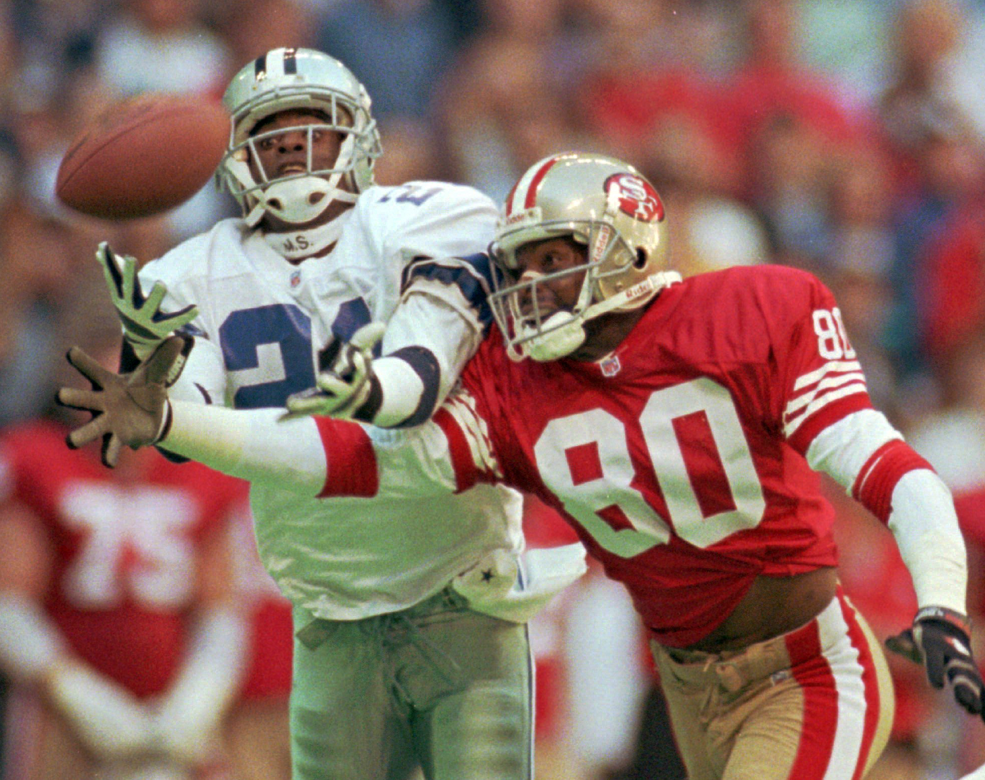 FILE - Dallas Cowboys defender Deion Sanders (21) knocks the ball away from San Francisco 49ers receiver Jerry Rice (80) in the second quarter of an NFL football game in Irving, Texas, Nov. 12, 1995. The 49ers-Cowboys playoff history is a rich one from back-to-back conference title games in the early 1970s, the iconic “Catch” in the 1981 season and then the heated rivalry in the 1990s when the Cowboys won the first two meetings on the way to Super Bowl titles and then the Niners took the third game. 
