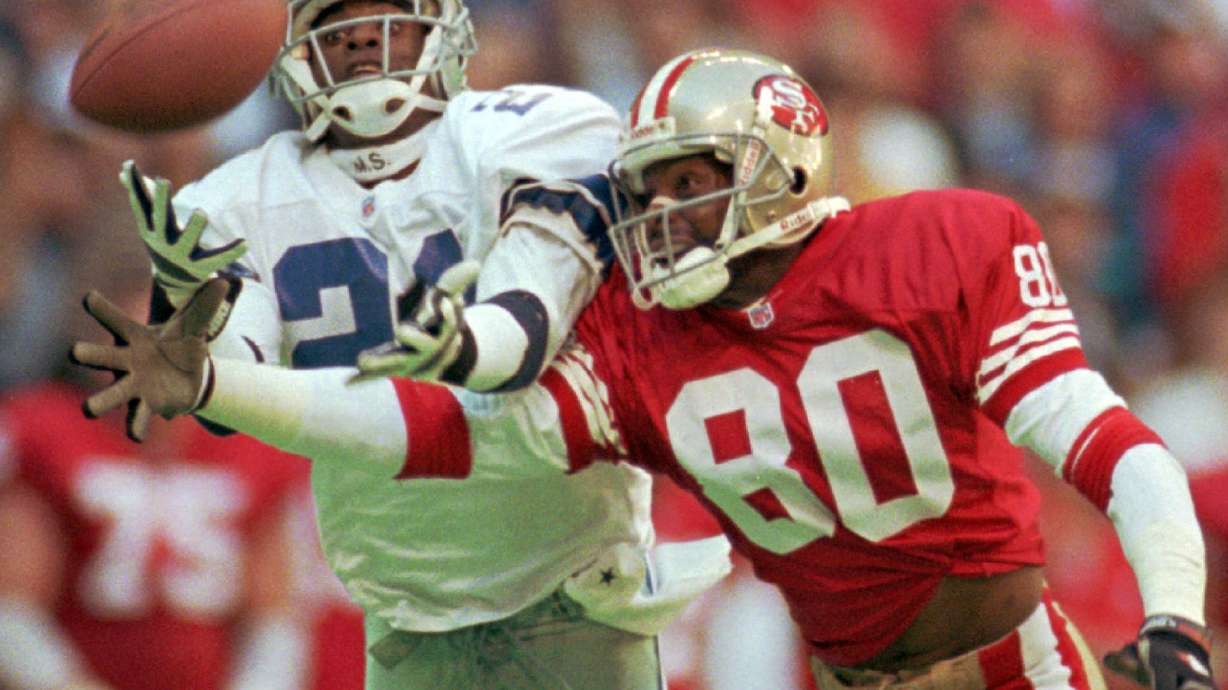 FILE - Dallas Cowboys defender Deion Sanders (21) knocks the ball away from San Francisco 49ers receiver Jerry Rice (80) in the second quarter of an NFL football game in Irving, Texas, Nov. 12, 1995. The 49ers-Cowboys playoff history is a rich one from back-to-back conference title games in the early 1970s, the iconic “Catch” in the 1981 season and then the heated rivalry in the 1990s when the Cowboys won the first two meetings on the way to Super Bowl titles and then the Niners took the third game.