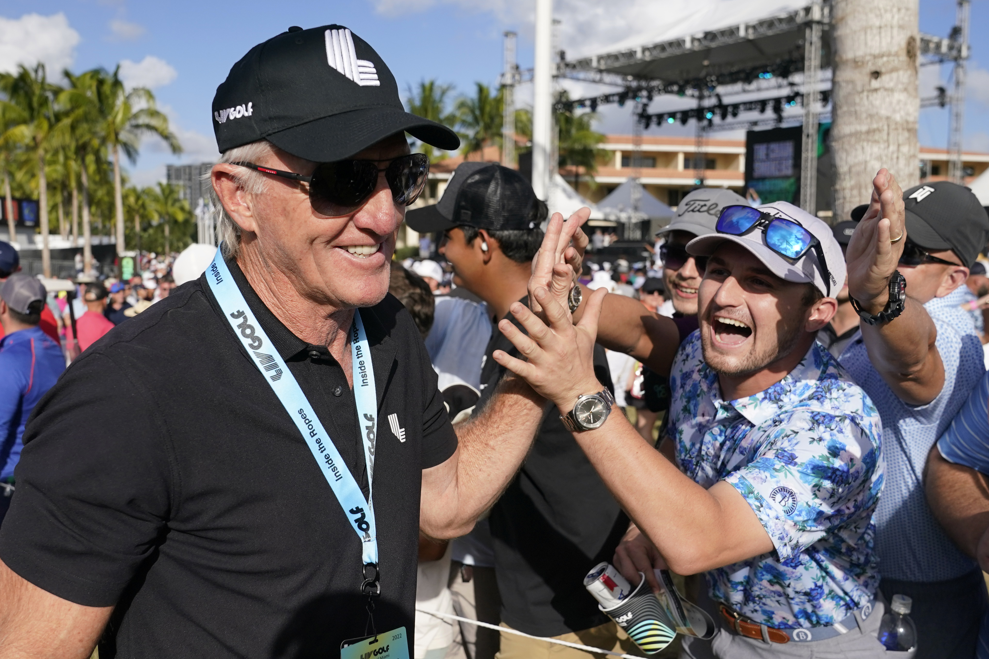 FILE - LIV Golf CEO Greg Norman, left, walks off the course after the final round of the LIV Golf Team Championship at Trump National Doral Golf Club, Sunday, Oct. 30, 2022, in Doral, Fla. Saudi-funded LIV Golf has a television partner five weeks before the start of its second season, announcing Thursday, Jan. 19, 2023, it has an agreement with The CW to air tournaments on the weekend and stream the first rounds on The CW's app.