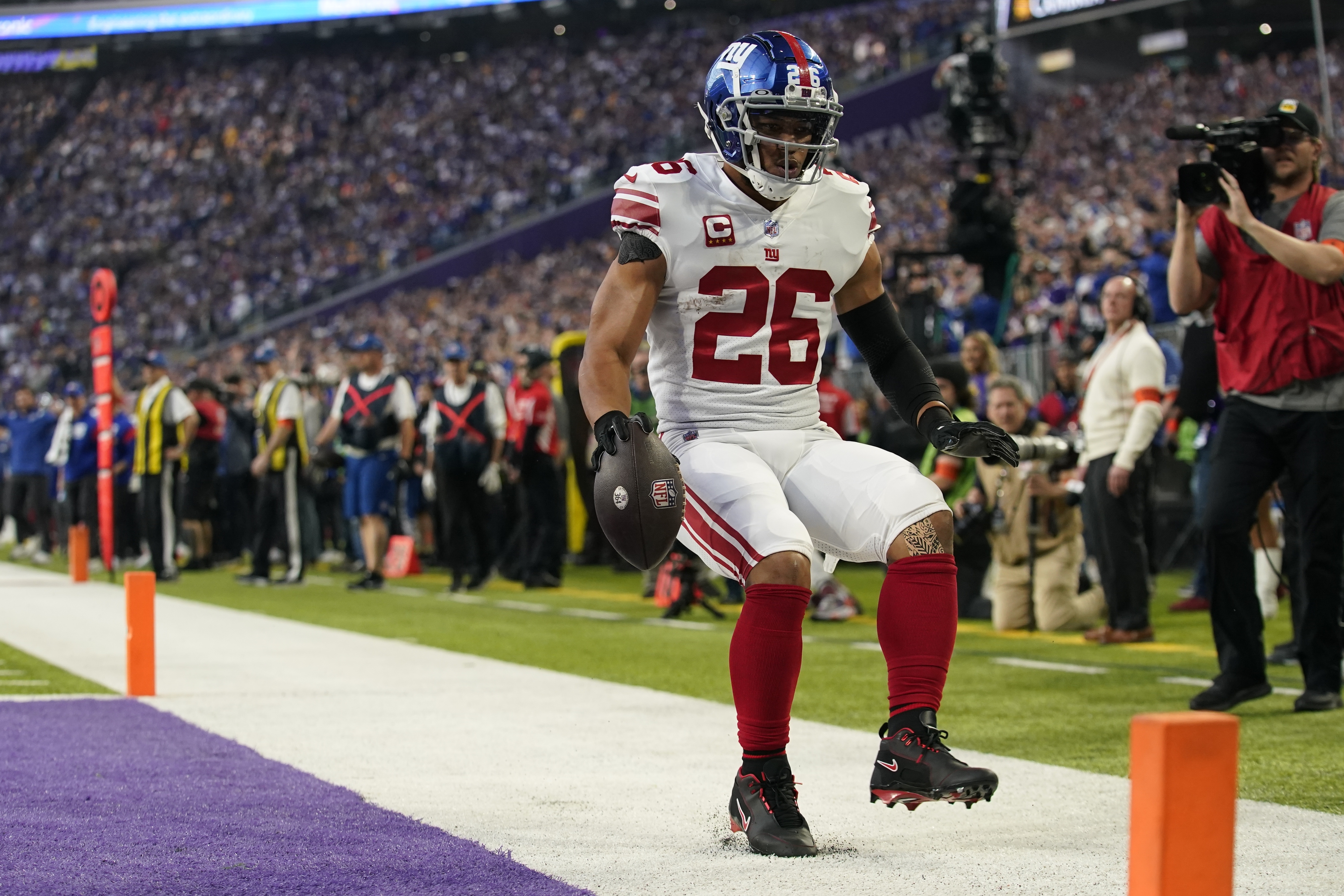 New York Giants' Saquon Barkley runs for a touchdown during the first half of an NFL wild card football game against the Minnesota Vikings Sunday, Jan. 15, 2023, in Minneapolis. 