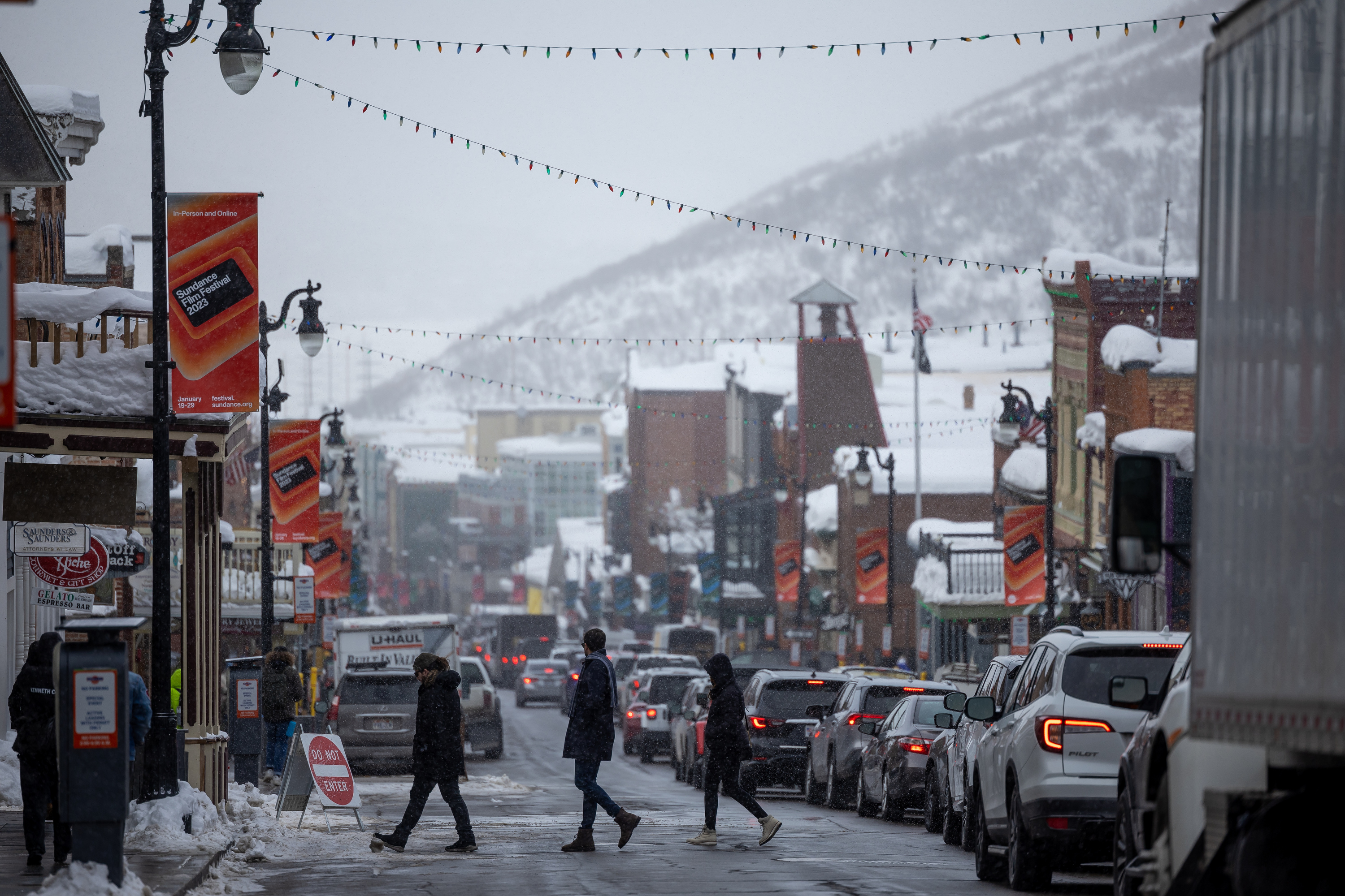 Pedestrians cross Main Street as traffic is snarled on the opening day of the Sundance Film Festival in Park City on Thursday. After two years of holding the Sundance Film Festival in a virtual capacity, the renowned festival on Thursday returned to Park City in all of its former glory.