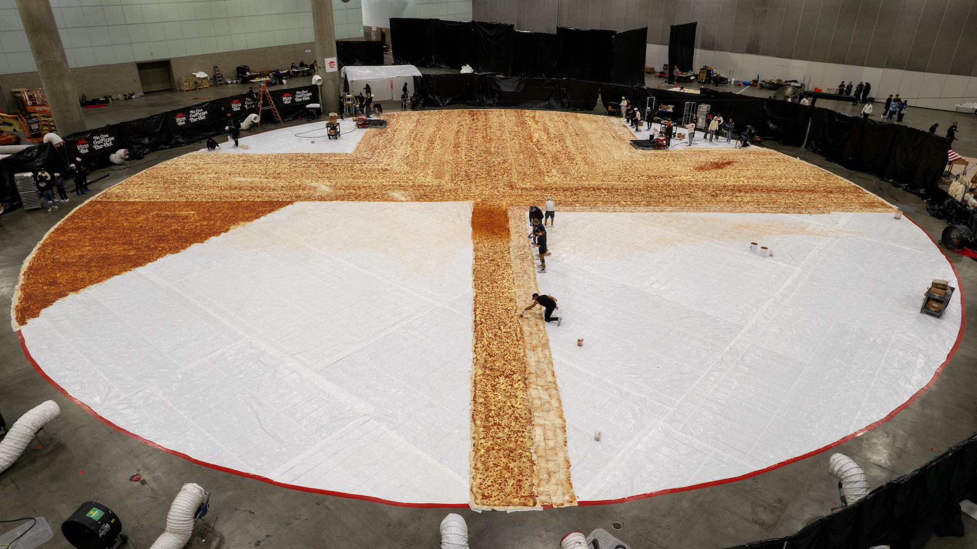 Cooks work inside the Los Angeles Convention center as Pizza Hut attempts to create the World's largest pizza of 14,101 square feet in Los Angeles, Jan. 18.
