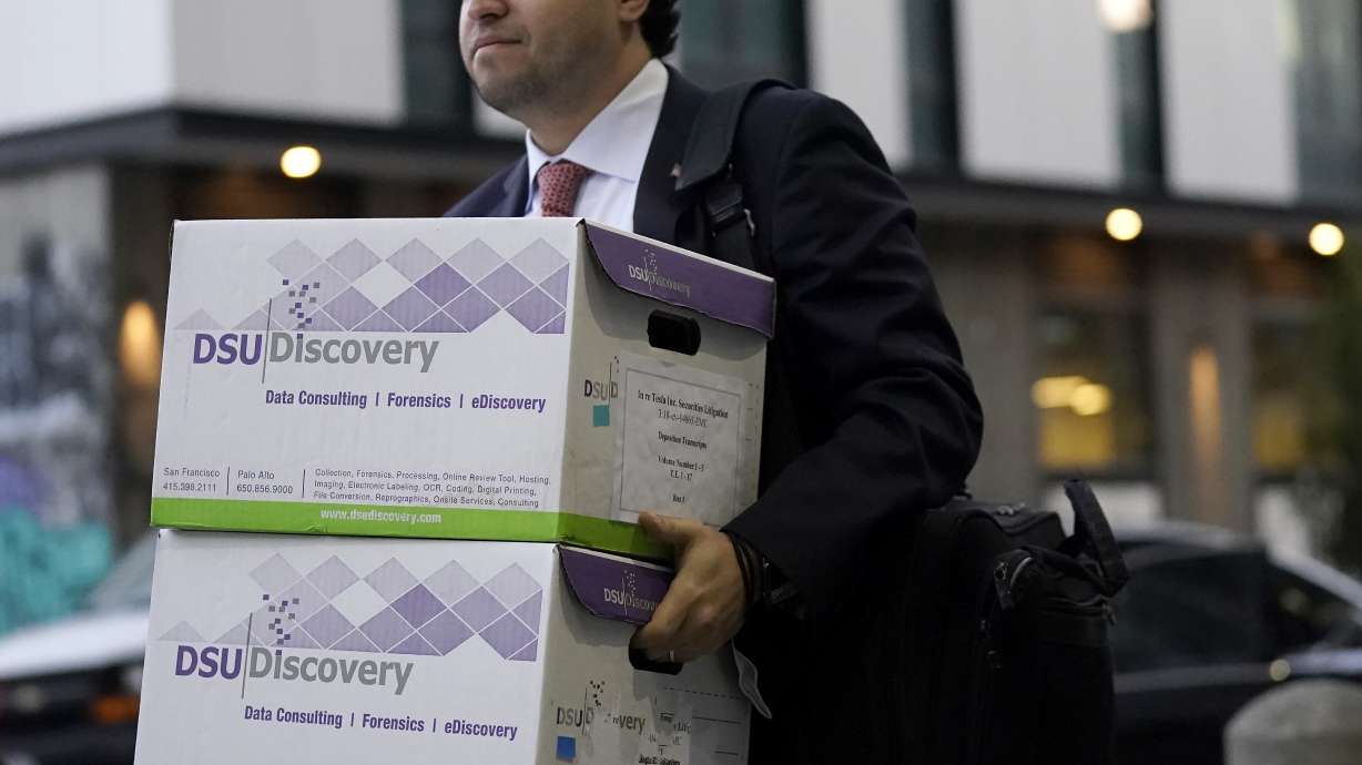 Documents related to the class-action lawsuit on behalf of investors who owned Tesla stock in August 2018 are carried toward a federal courthouse in San Francisco on Friday.