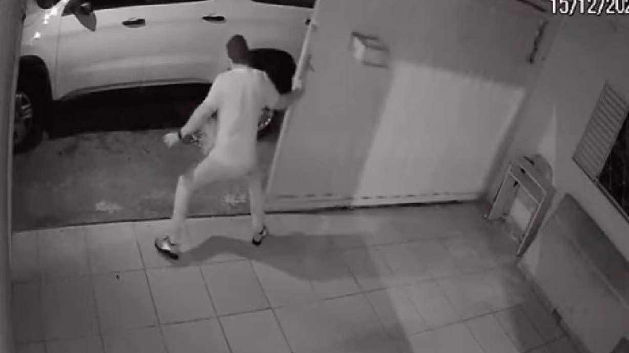 Man in Goiânia, Brazil, attempts to close his gate.