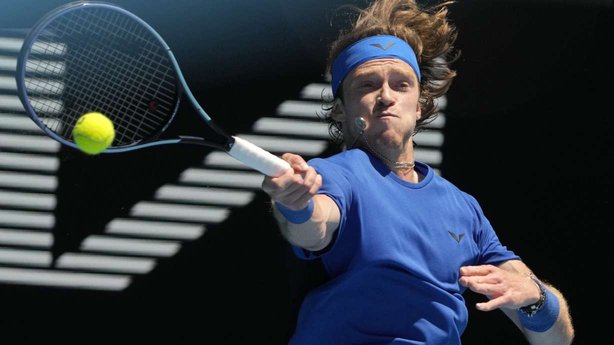 Andrey Rublev of Russia plays a forehand return to Daniel Evans of Britain during their third round match at the Australian Open tennis championship in Melbourne, Australia, Saturday, Jan. 21, 2023.